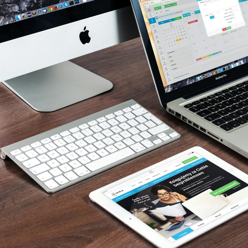 turned on imac beside macbook on table